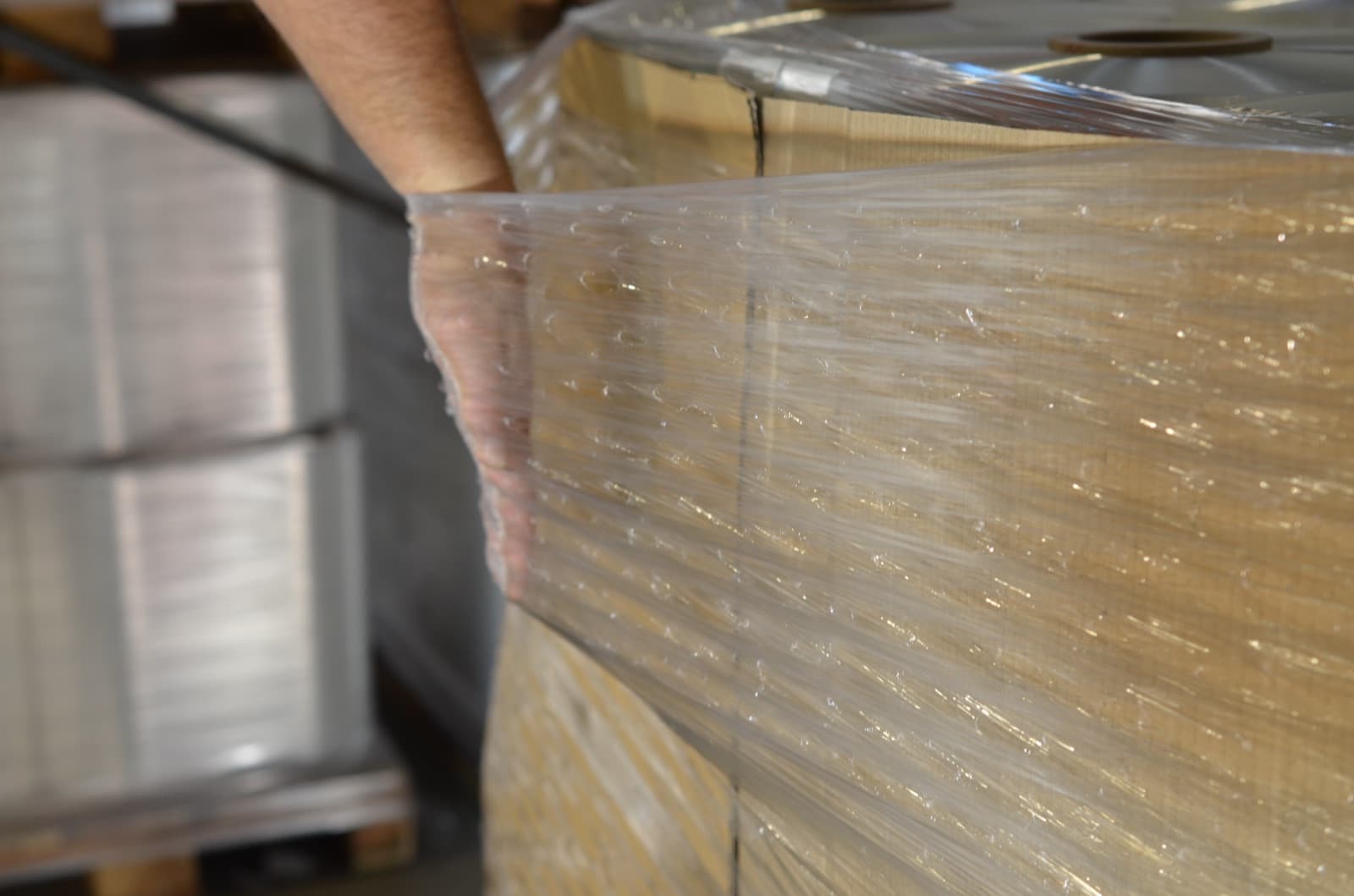 The edge of a pallet wrapped in reinforced film, checked by hand after wrapping