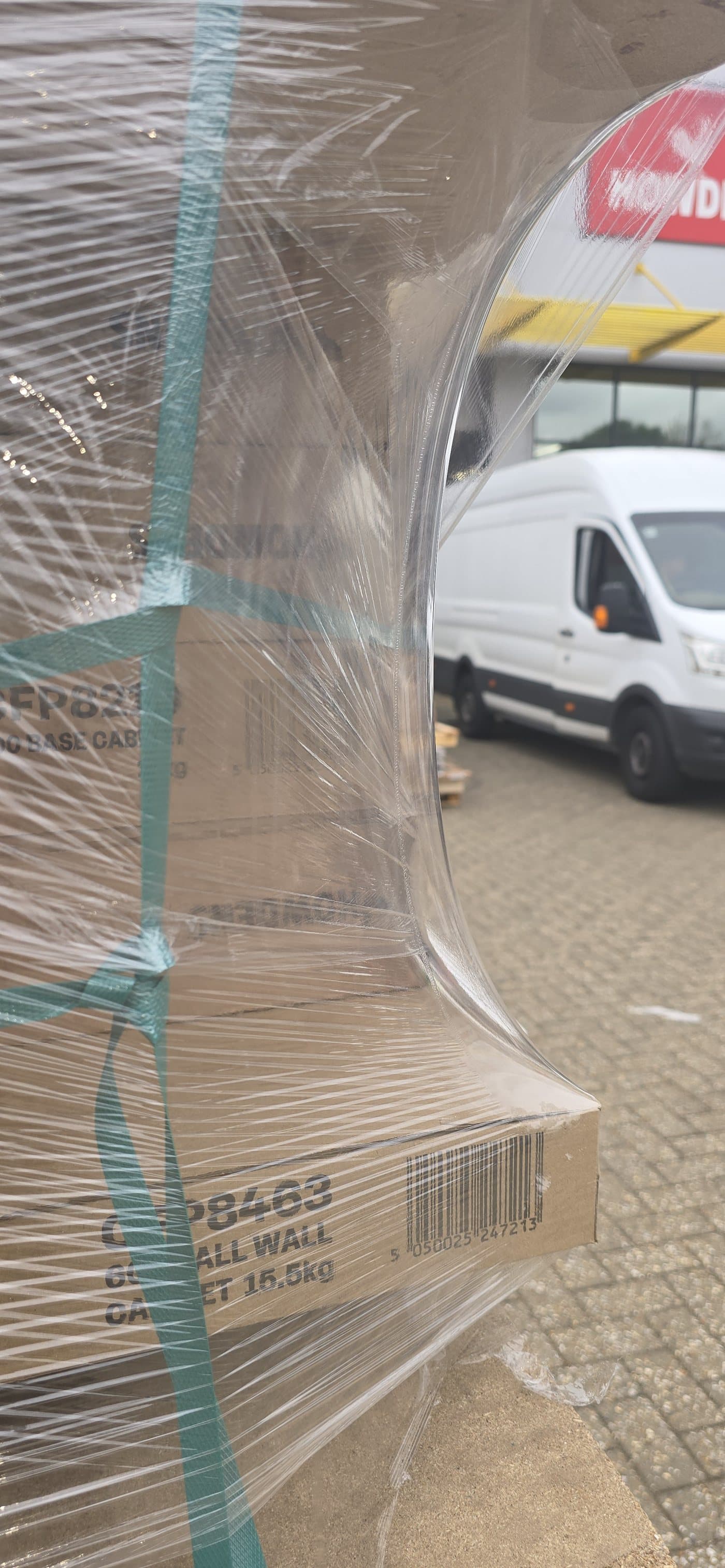 Hyper Wrap film over a pallet corner, holding the load's own strapping tight underneath it
